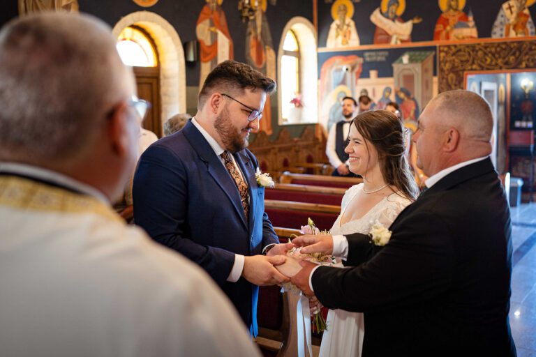 Tatal miresei preda mana fiicei lui mirelui la intrarea in biserica