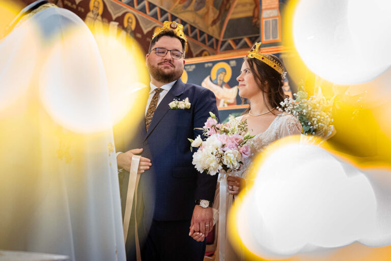 Portret cu mirii in biserica cu cununiile pe cap